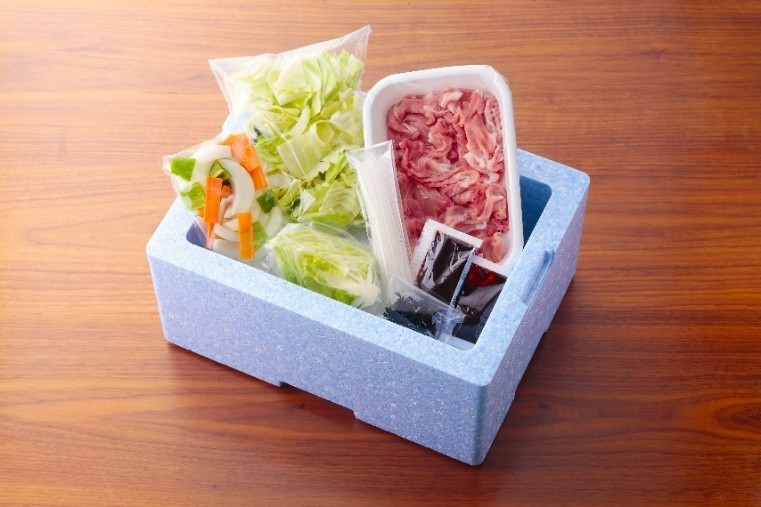 ヨシケイお試しセットの梱包。青い保冷箱に野菜や肉が小分けされて入っている様子
